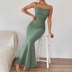 Dark green spaghetti strap maxi dress with ruched bodice and flared long skirt.