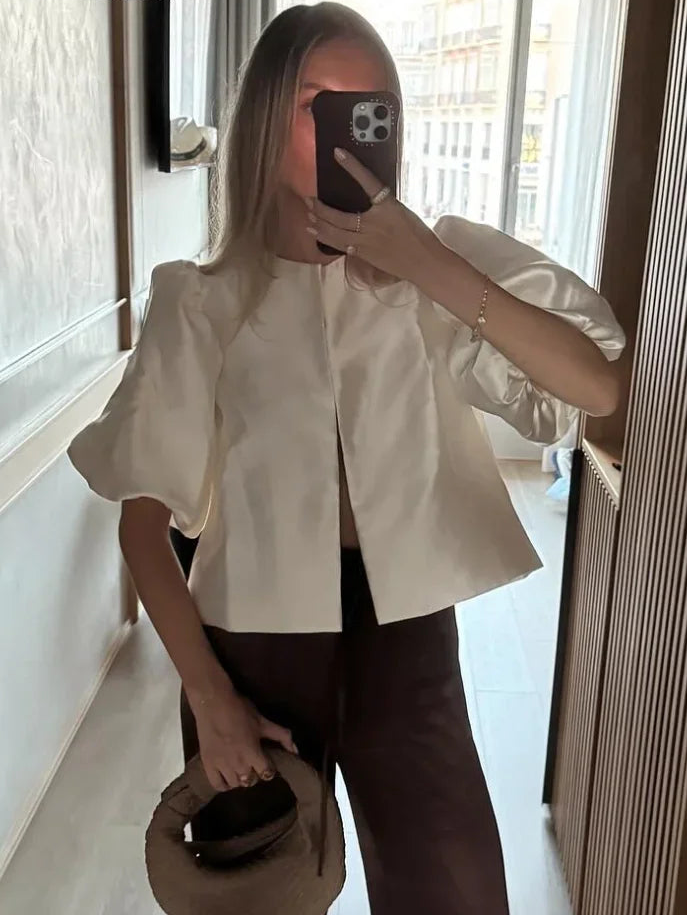 White puff sleeve blouse with front button placket and side pleat detail