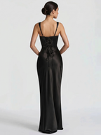 Black backless maxi dress with thin spaghetti straps and open back, smooth satin skirt